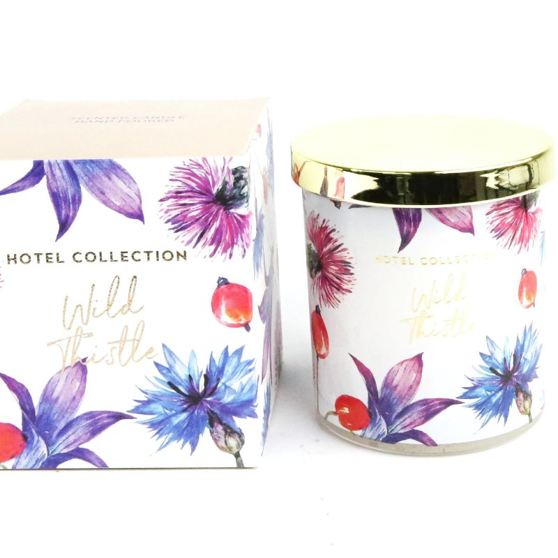 Candle with floral design and 'Hotel Collection' branding on a white background
