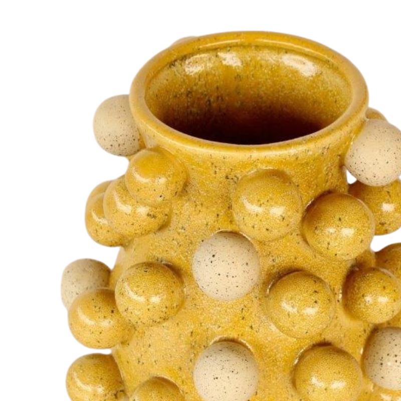 Yellow ceramic vase with spherical protrusions on a white background