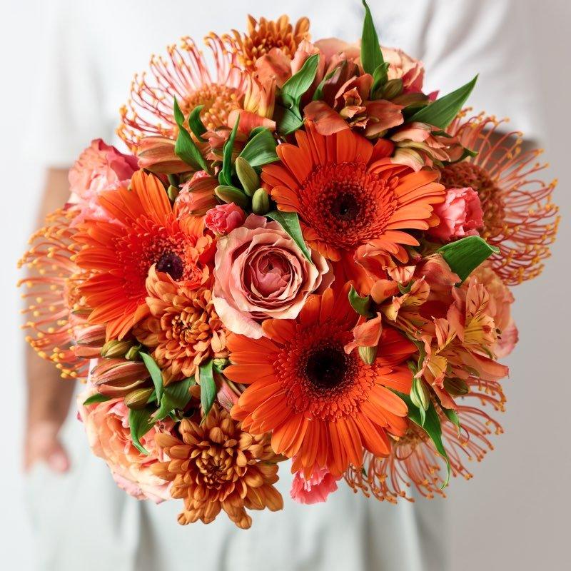 Amber Bouquet by Fabulous Flowers & Gifts – vibrant mix of orange gerberas, roses, pincushions, and lush greenery