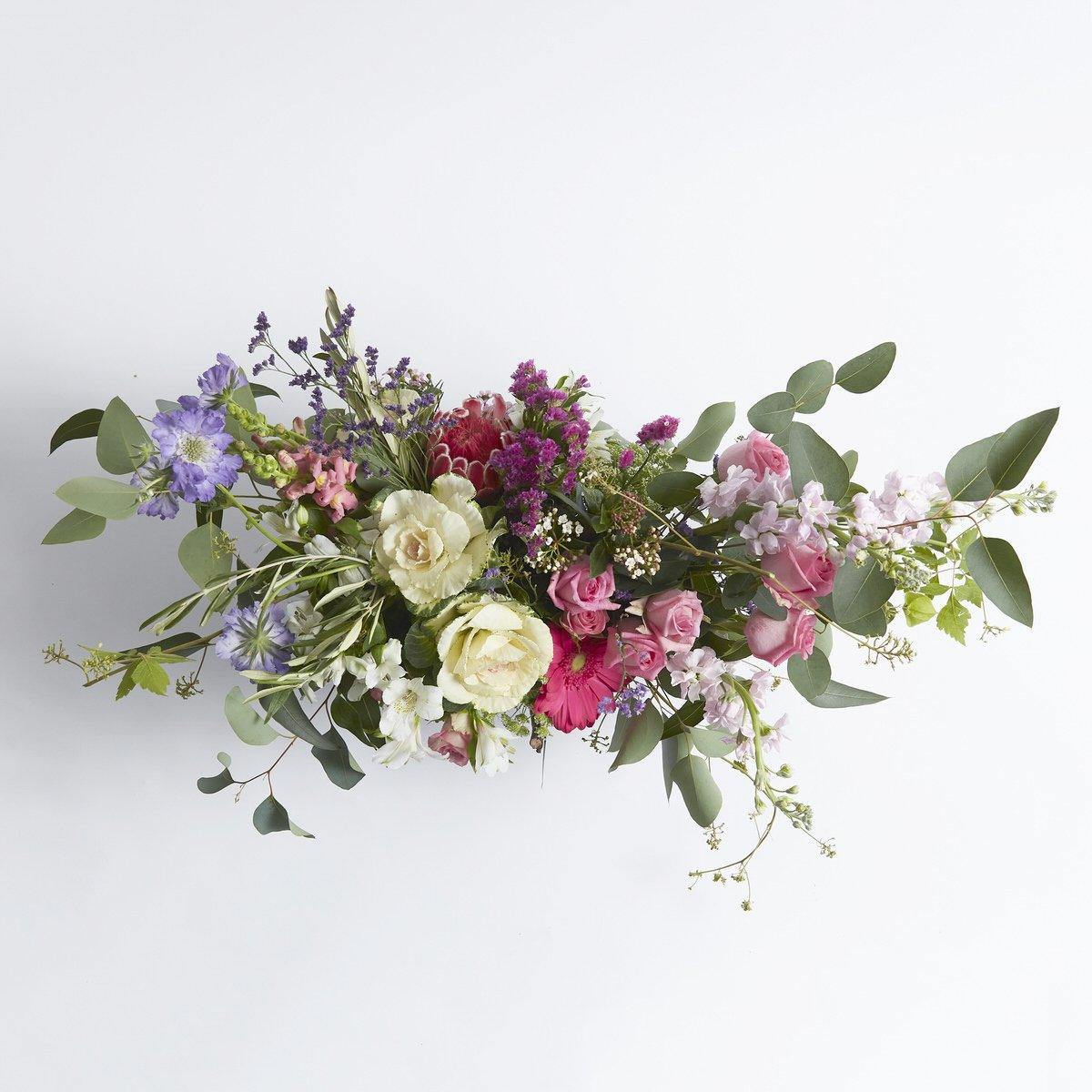 Elegant, gerberas, ornamental kale, stocks in the Bloom Blush Flower Arrangement