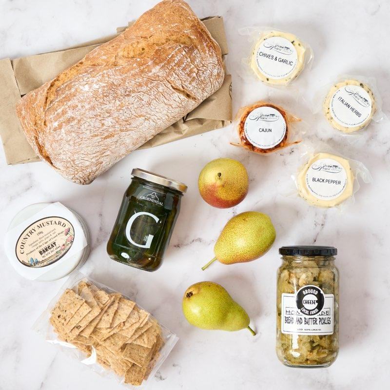 Cheese and Bread Hamper packed with delicious snacks inclding pears, fig preserve, mustard and freshly baked bread. Delivered same day by Fabulous Flowers.