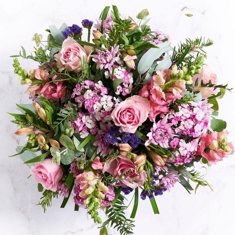 Flower arrangement with Alstromeria, pink roses,  purple statice, pink snapdragons, sweet william and wild greenery
