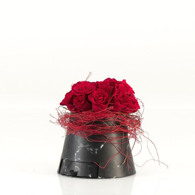 Red roses in a faux-marble container and red twine - Fabulous Flowers