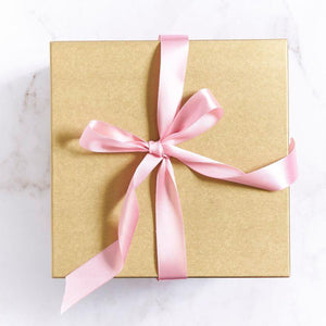 Gold box with pink ribbon filled with 24 pink roses for romantic gestures | Fabulous Flowers