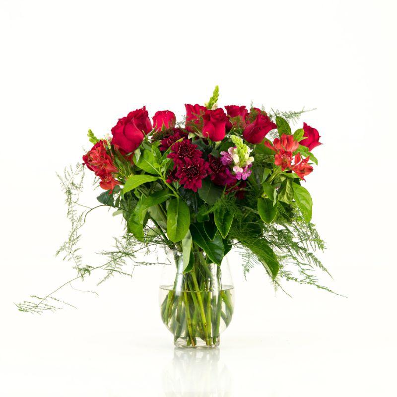 12 red roses with other red flowers in a glass vase from Fabulous Flowers