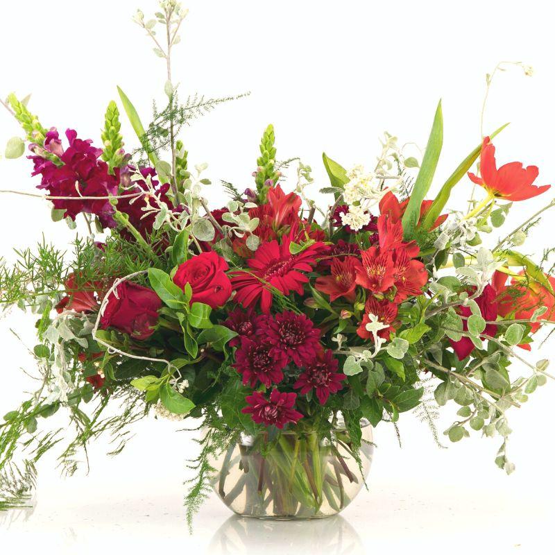 Close up of red flower arrangement in round vase by Fabulous Flowers