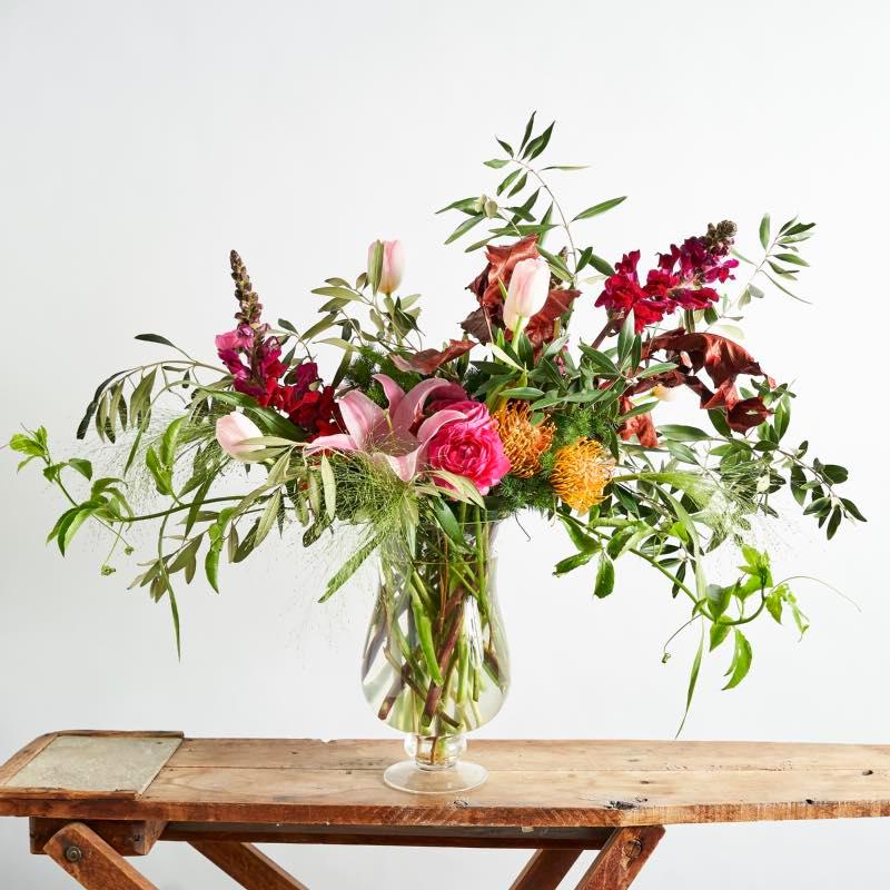 Stylish and elegant modern flower arrangement in glass vase with lilies, snapdragons, tulips and greenery - Fabulous Flowers